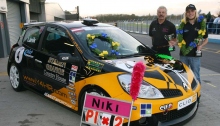 Niki Lanik con su coche de carreras de Juventud por los Derechos Humanos y sus medallas